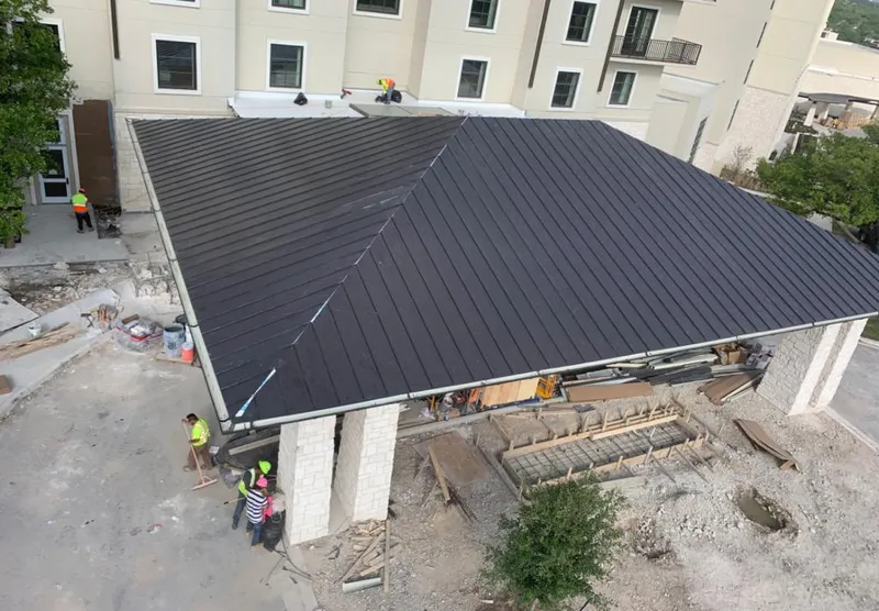Metal roofing installation team working on a commercial building in Bellmead